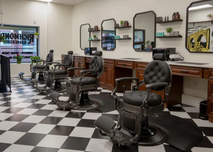 Barber chairs, mirrors, and checkerboard floor inside our Carytown barbershop