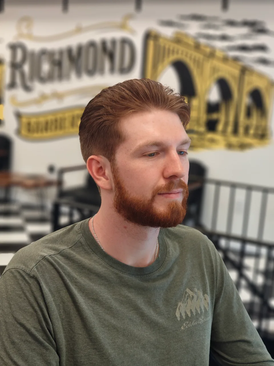 Side-parted auburn haircut paired with a neatly shaped full beard