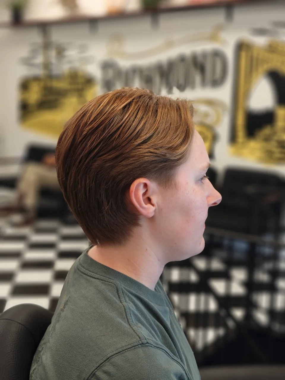 Long copper-colored hair swept back in layers with a subtle taper above the ear